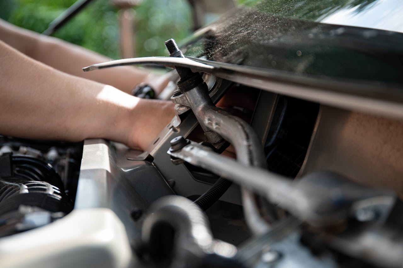 team-01 Close-up shot of a mechanic repairing a car engine with focus on tools and hands.